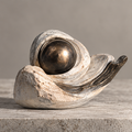 Layered ivory-toned wave sculpture surrounding a bronze-toned orb, without text overlay